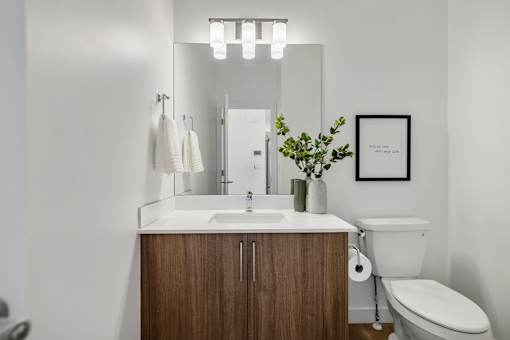 A bathroom with a wooden vanity and white toilet.