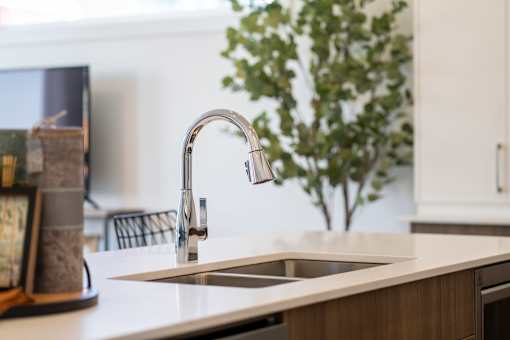 A kitchen sink with a chrome faucet.