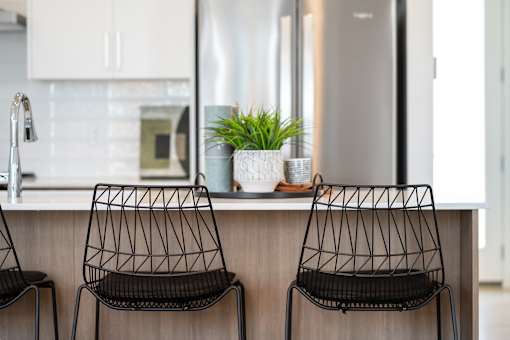 Two black chairs are placed in front of a kitchen counter.