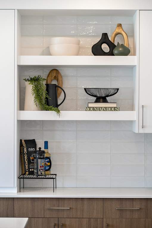 A kitchen cabinet with a white interior and shelves containing various items.