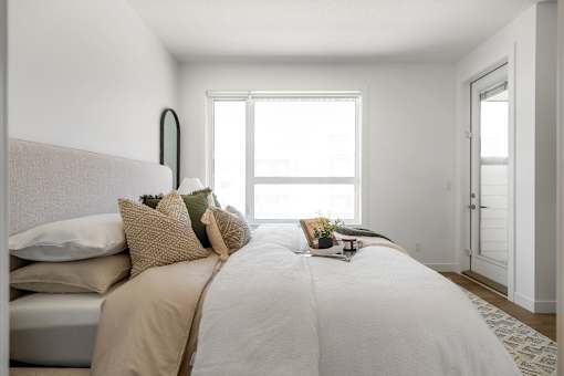 A bedroom with a large bed and a window.