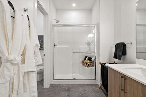 A bathroom with a white shower stall and a white sink.