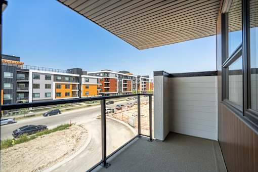 A balcony overlooks a road with cars and buildings in the distance.