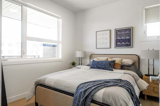 A bedroom with a large bed and two framed pictures on the wall.
