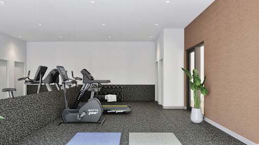 A gym with a row of treadmilers and a blue yoga mat on the floor.