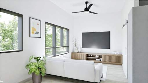 A living room with a white couch, a television, and a ceiling fan.