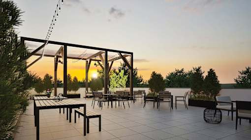 A sunset view of a patio with tables and chairs.