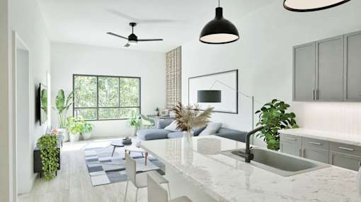 A modern kitchen with a marble countertop and a ceiling fan.