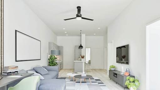 A living room with a grey sofa, a coffee table, a television, and a fireplace.