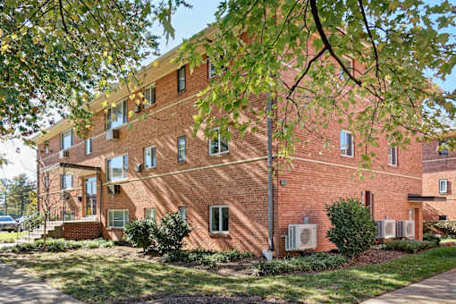 A red brick building with trees in front.