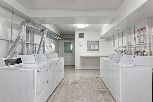 A clean, white industrial room with multiple machines and pipes.