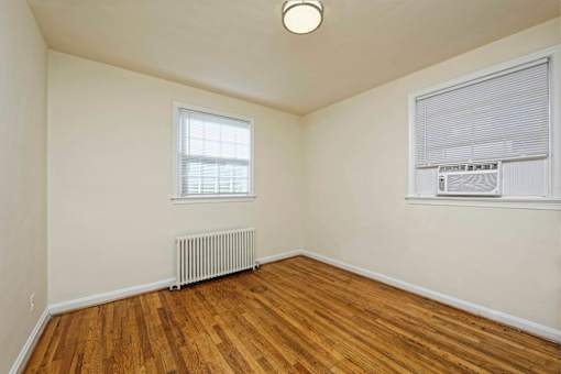 A room with a window and a radiator on the floor.