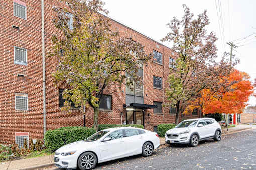Two cars parked in front of a brick building.