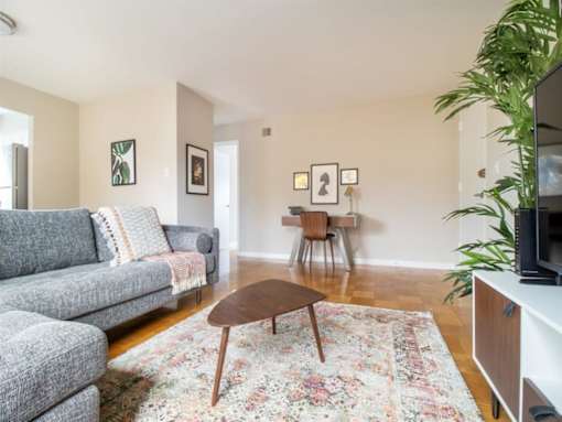 A living room with a grey couch and a wooden coffee table.