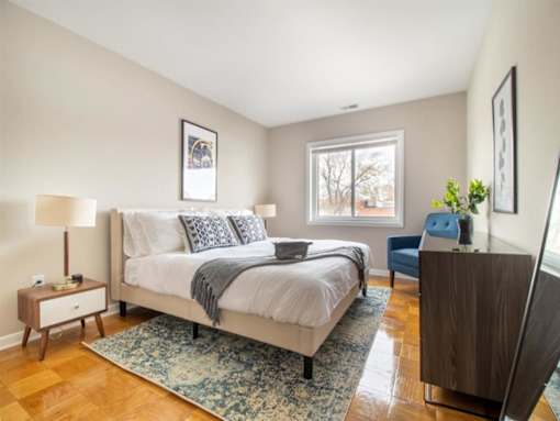 A bedroom with a large bed and a wooden floor.