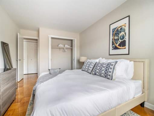 A bedroom with a large bed and a painting on the wall.
