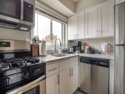 A modern kitchen with a stove, microwave, and dishwasher.