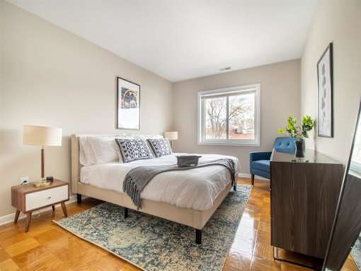 A bedroom with a large bed and a wooden floor.