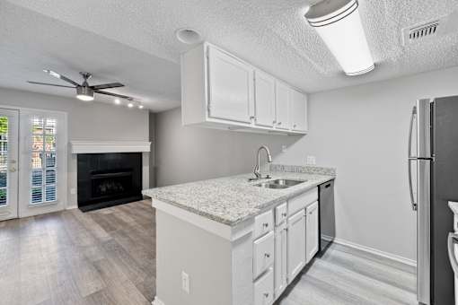 A kitchen with a white countertop and a black refrigerator.