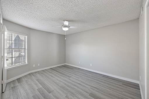 A room with a window and a ceiling fan.