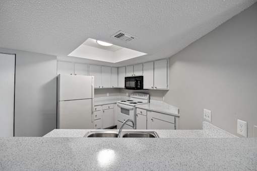 A kitchen with white cabinets and appliances.