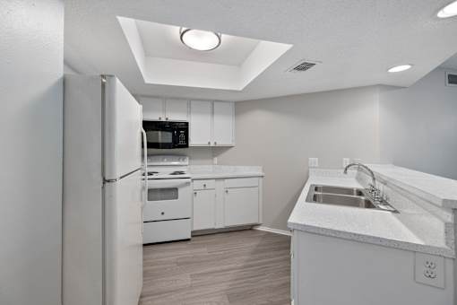 A modern kitchen with white appliances and cabinets.