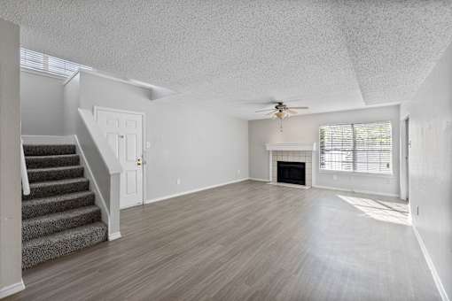 A spacious living room with a staircase leading to the upper floor.