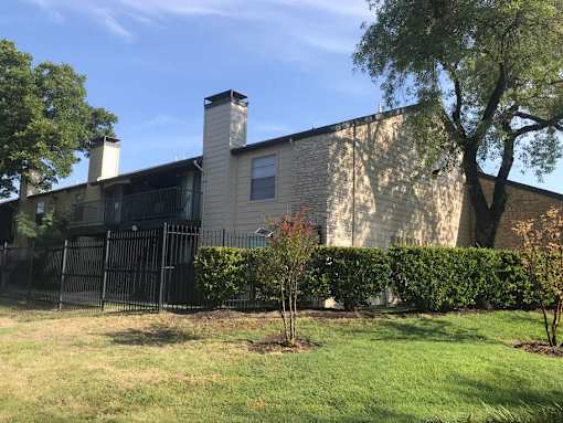 A house with a black fence and a tree in front.