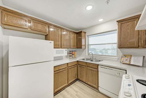 A kitchen with wooden cabinets and white appliances.