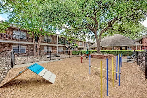 A playground with a slide, swings, and a seesaw.