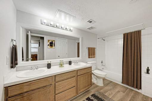 A bathroom with a white countertop and brown wooden drawers.