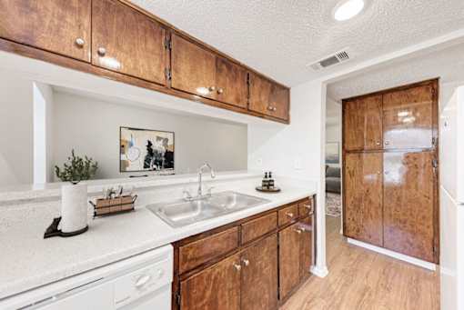A kitchen with wooden cabinets and a white counter top.