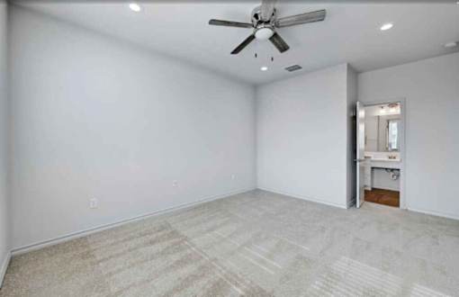 A room with a ceiling fan and carpeted floor.