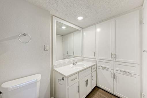 A white bathroom with a tub, sink, and mirror.