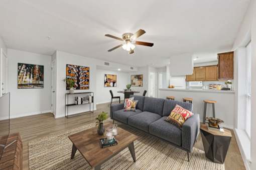 A living room with a grey couch and a wooden coffee table.