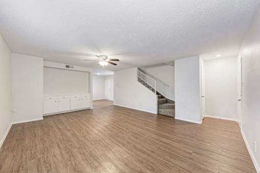 A room with wooden flooring and a staircase.
