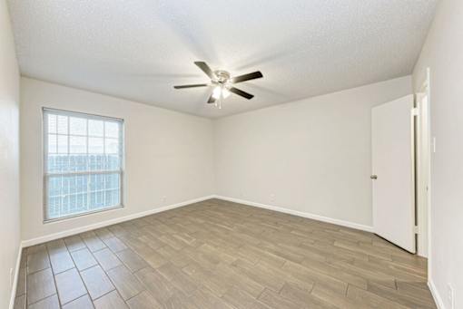A room with a ceiling fan and a window.