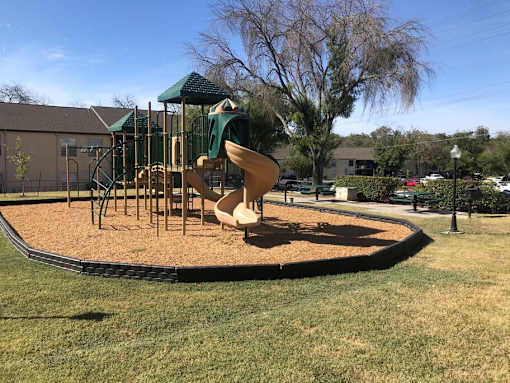 A playground with a slide and a green canopy.