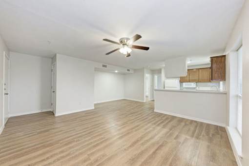 A room with a ceiling fan and wooden flooring.