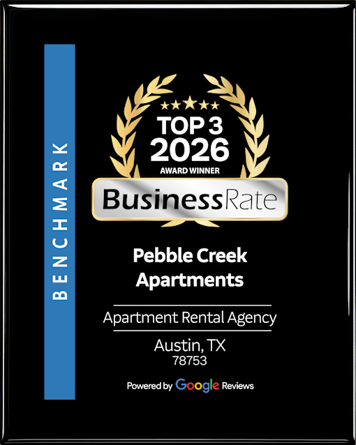 A black and gold award sign for Pebble Creek Apartments.