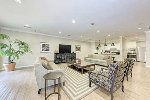 A living room with a striped rug and a wooden floor.