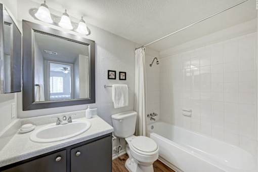 A white bathroom with a sink, toilet, and bathtub.