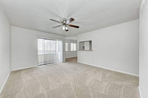 A room with a ceiling fan and carpeted floor.