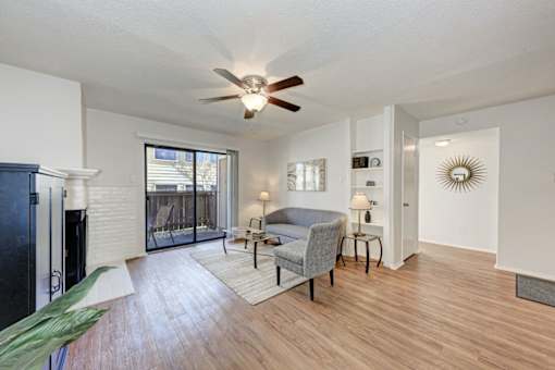A living room with a grey couch and a ceiling fan.
