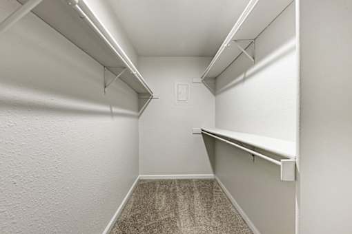 A white hallway with a carpeted floor and white walls.