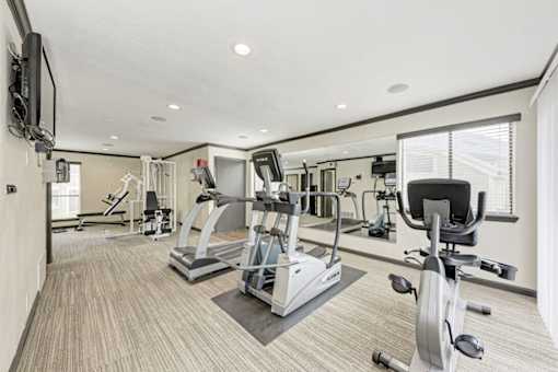 A spacious home gym with a variety of exercise equipment.
