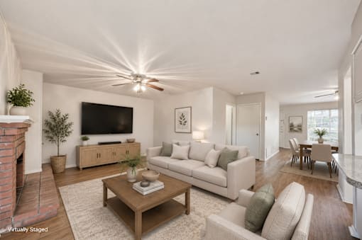A living room with a fireplace and a flat screen TV.
