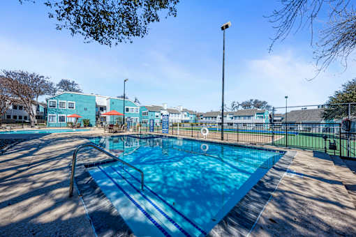 A blue swimming pool with a metal ladder on the left side.