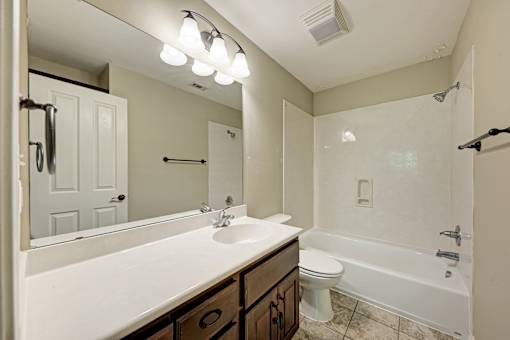 A bathroom with a white sink and a white toilet.