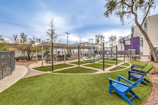 A park with a blue bench and a green lawn.